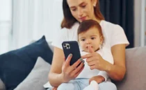 smartphone-in-hand-mother-with-her-little baby