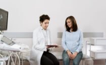 Pareja embarazada conversando con un pediatra durante una consulta prenatal