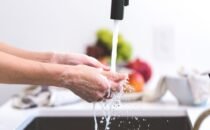 Madre lavándose las manos antes de cargar a su bebé recién nacido